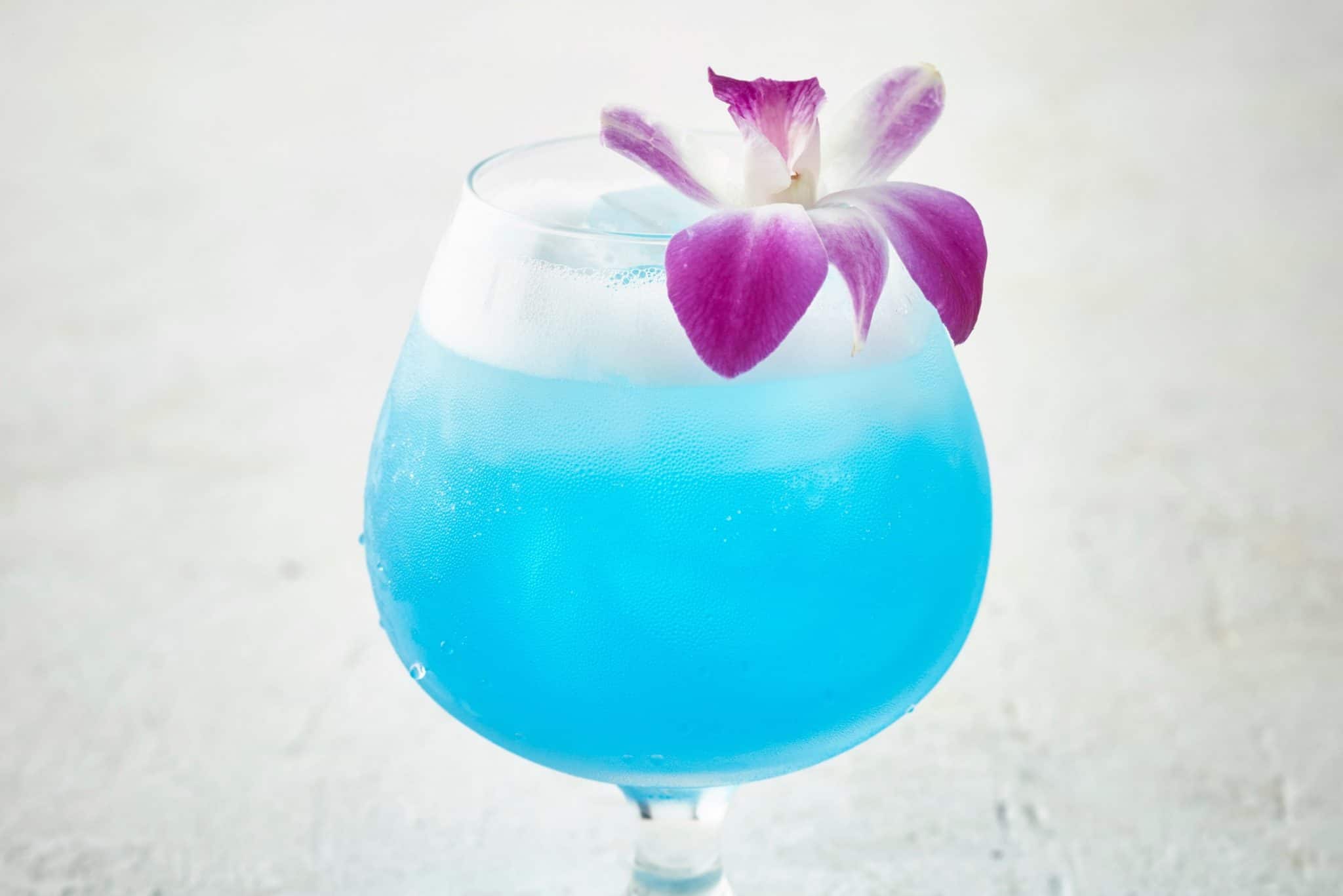 Sparkling Blue Hawaiian Cocktail topped with an orchid