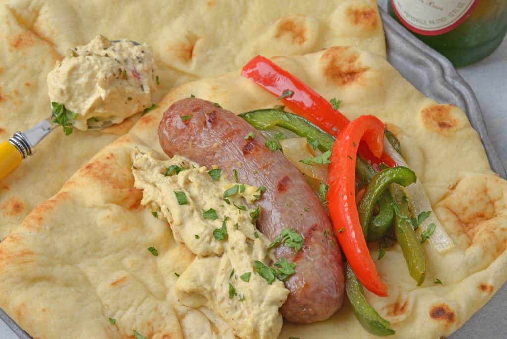 Mediterranean Yuengling Bratwurst use bratwurst injected with Yuengling, bell peppers and onion, garlic hummus and wrap them in naan. www.savoryexperiments.com