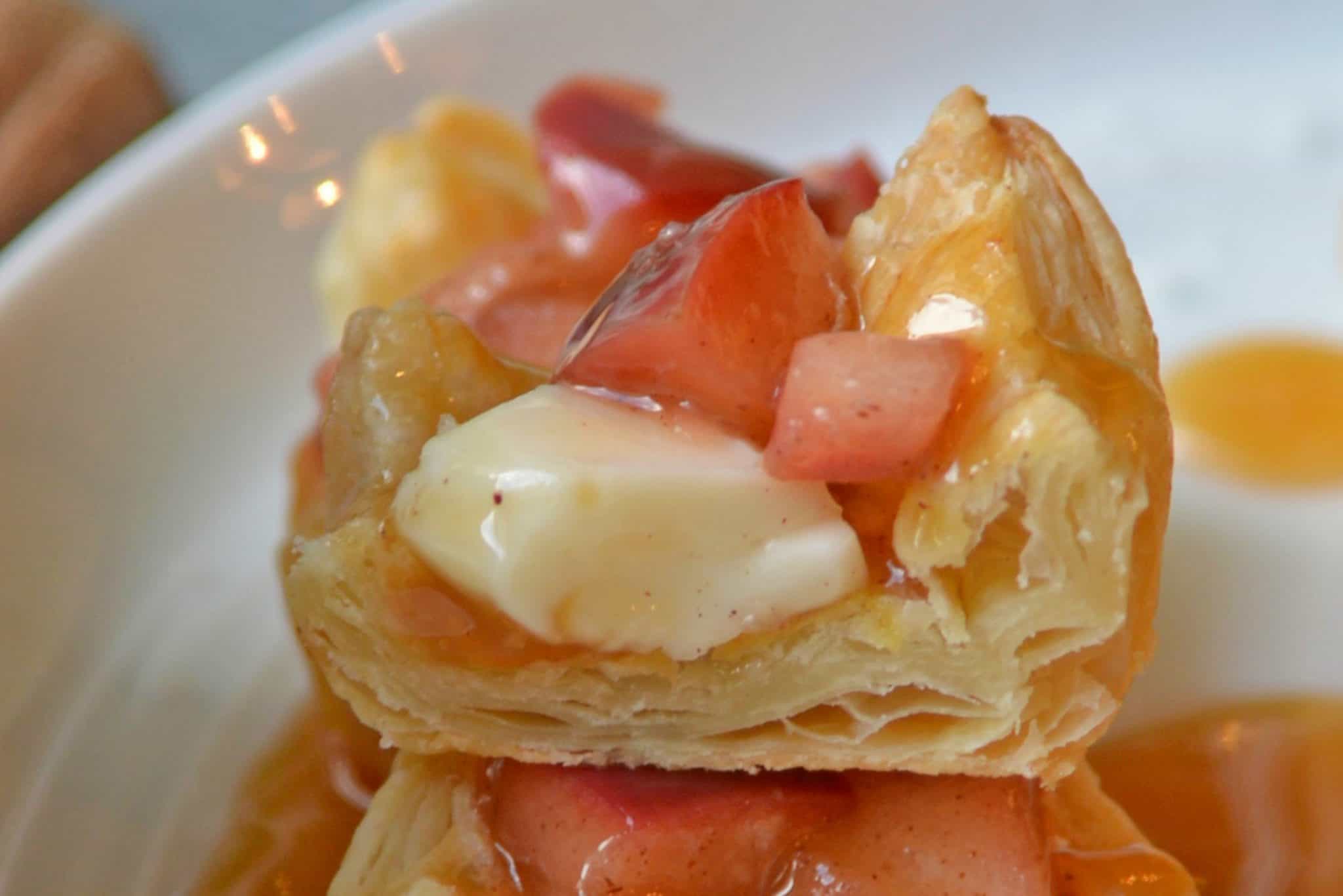 close up half of a puff pastry with apple and brie filling 
