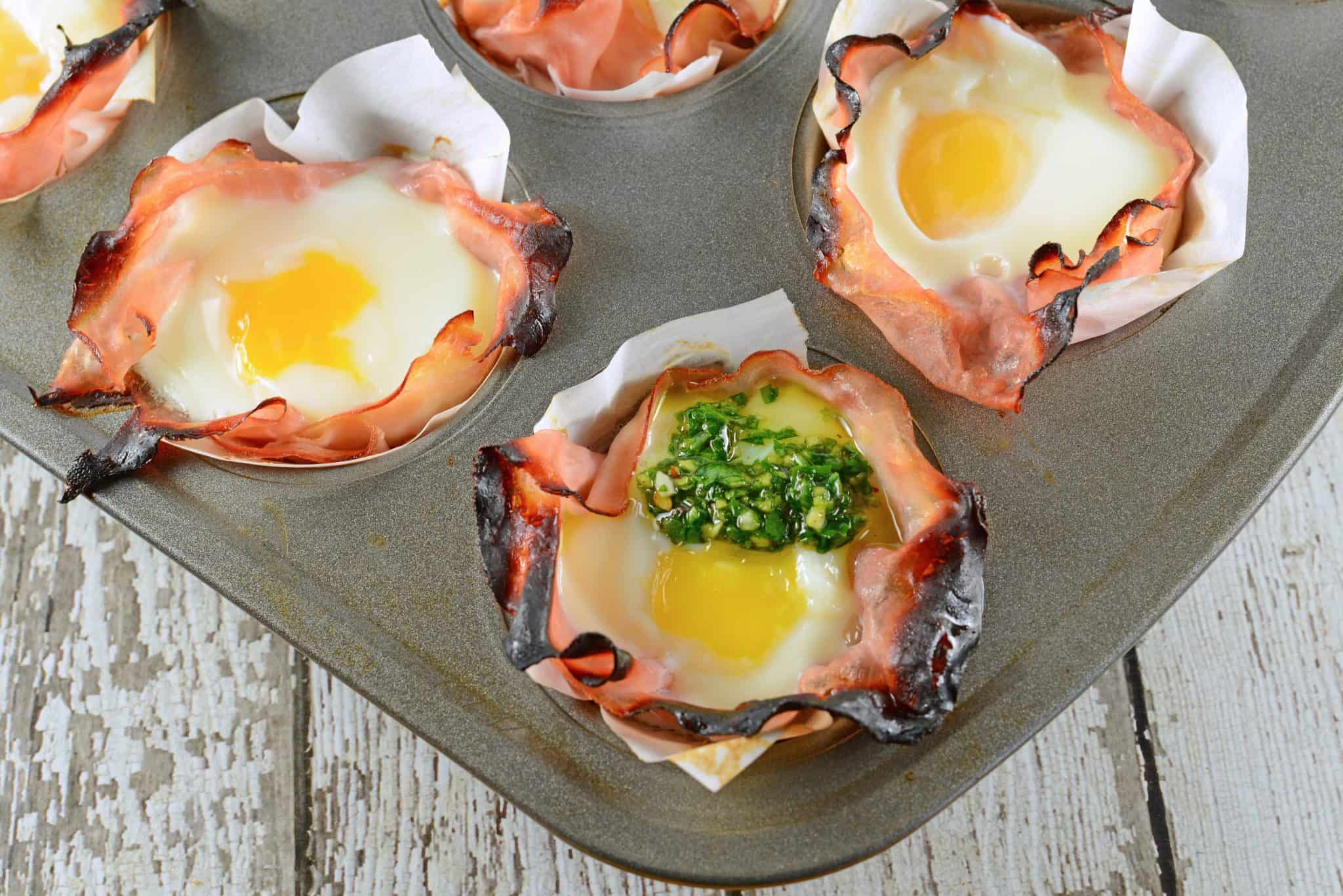 Chimichurri Egg Muffins are eggs baked in ham with a zesty chimichurri sauce made with fresh herbs and garlic. The perfect make ahead breakfast idea! #greeneggsandham #eggmuffins www.savoryexperiments.com 