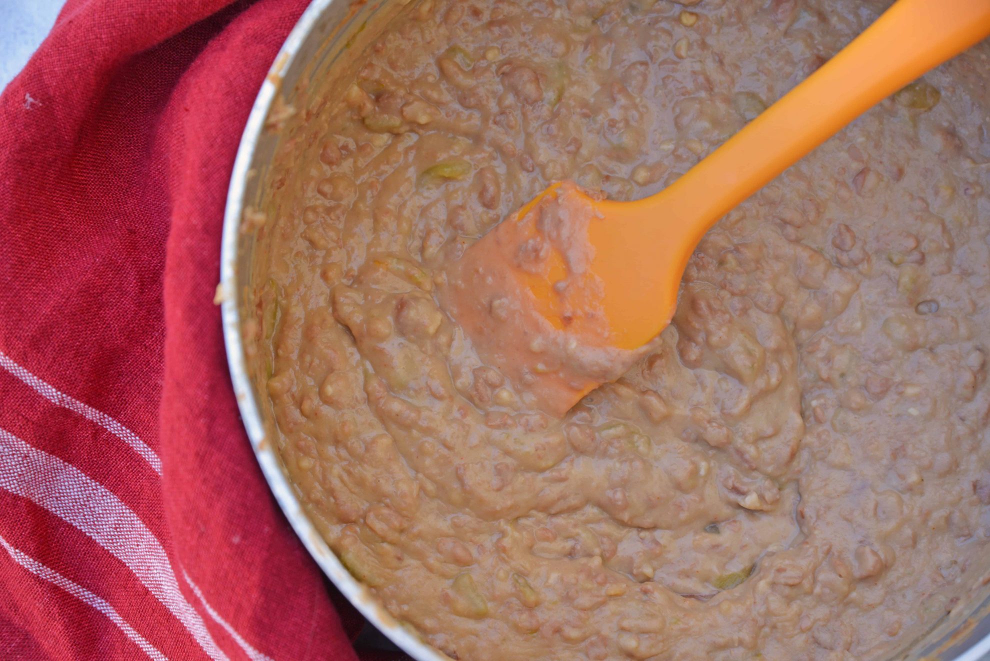 Mexican Refried Beans are an easy homemade refried bean recipe using pinto beans, green chilies, cheese and Mexican spices. Ready in just 15 minutes! #refriedbeans #mexicansidedish www.savoryexperiments.com 