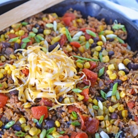Mexican Beef and Rice Casserole in a skillet with a wooden spoon