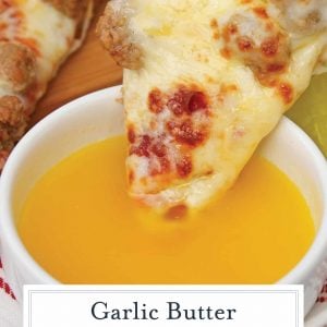 Pizza dipping into garlic butter sauce