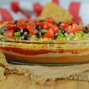 Easy party appetizers don't get much easier than this 7 layer dip! It takes chips and dip to a whole new level with refried beans, guacamole and sour cream! #7layerdip #beandip #sevenlayerdip www.savoryexperiments.com