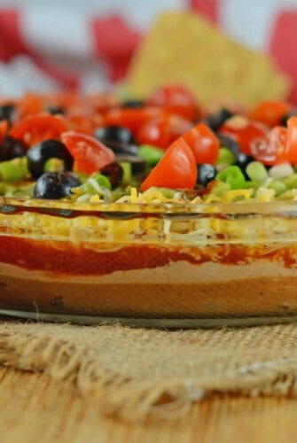 Easy party appetizers don't get much easier than this 7 layer dip! It takes chips and dip to a whole new level with refried beans, guacamole and sour cream! #7layerdip #beandip #sevenlayerdip www.savoryexperiments.com