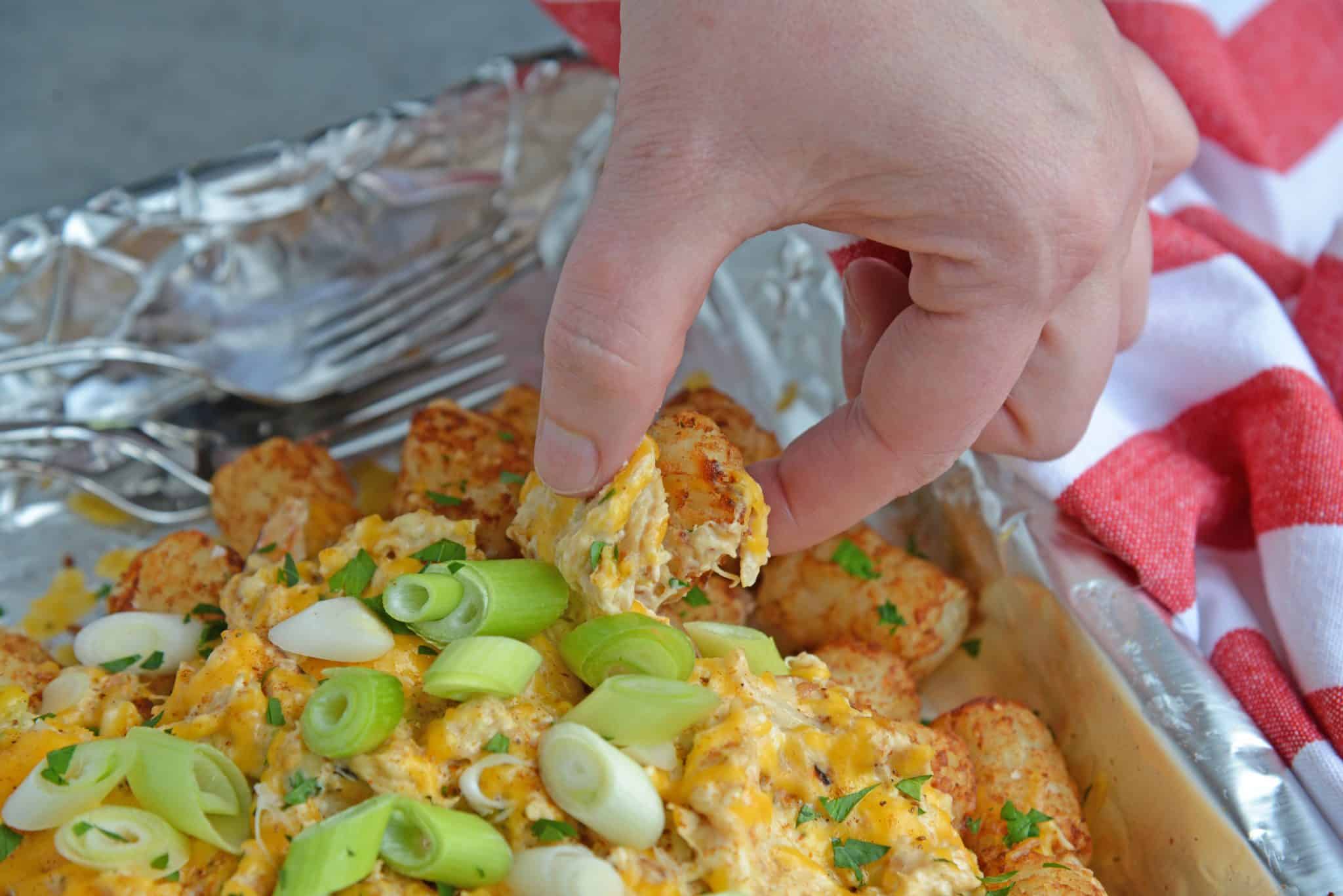 Crabby Totchos are crispy fried tater tots smothered in hot crab dip and topped with melty cheddar cheese. The perfect party appetizer! #tatertots #easyappetizerrecipes www.savoryexperiments.com 