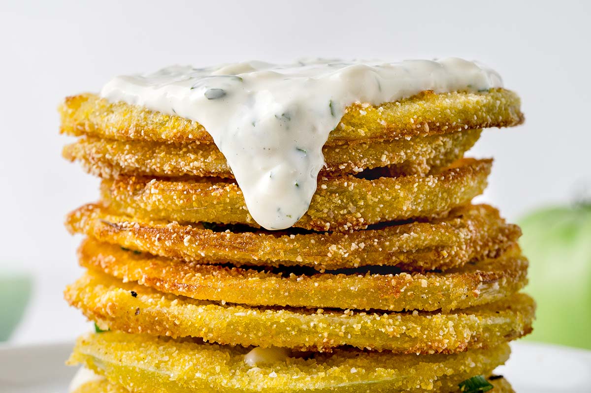 aioli sauce dripping off a stack of tomato slices