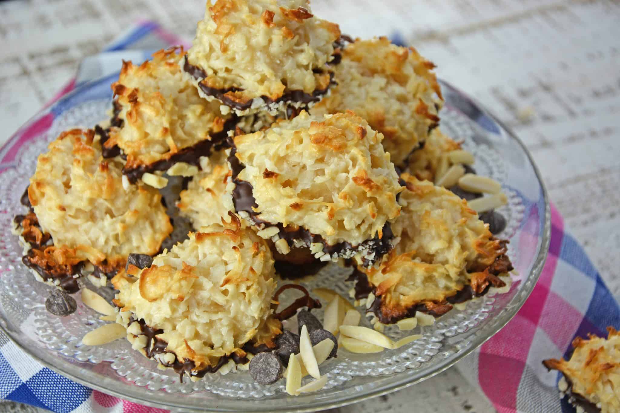 Almond Coconut Macaroons are light, fluffy coconut biscuits dipped in chocolate and almonds. Perfect as a dessert, for tea for as a an afternoon snack. #coconutmacaroons #macaroonsrecipe www.savoryexperiments.com 
