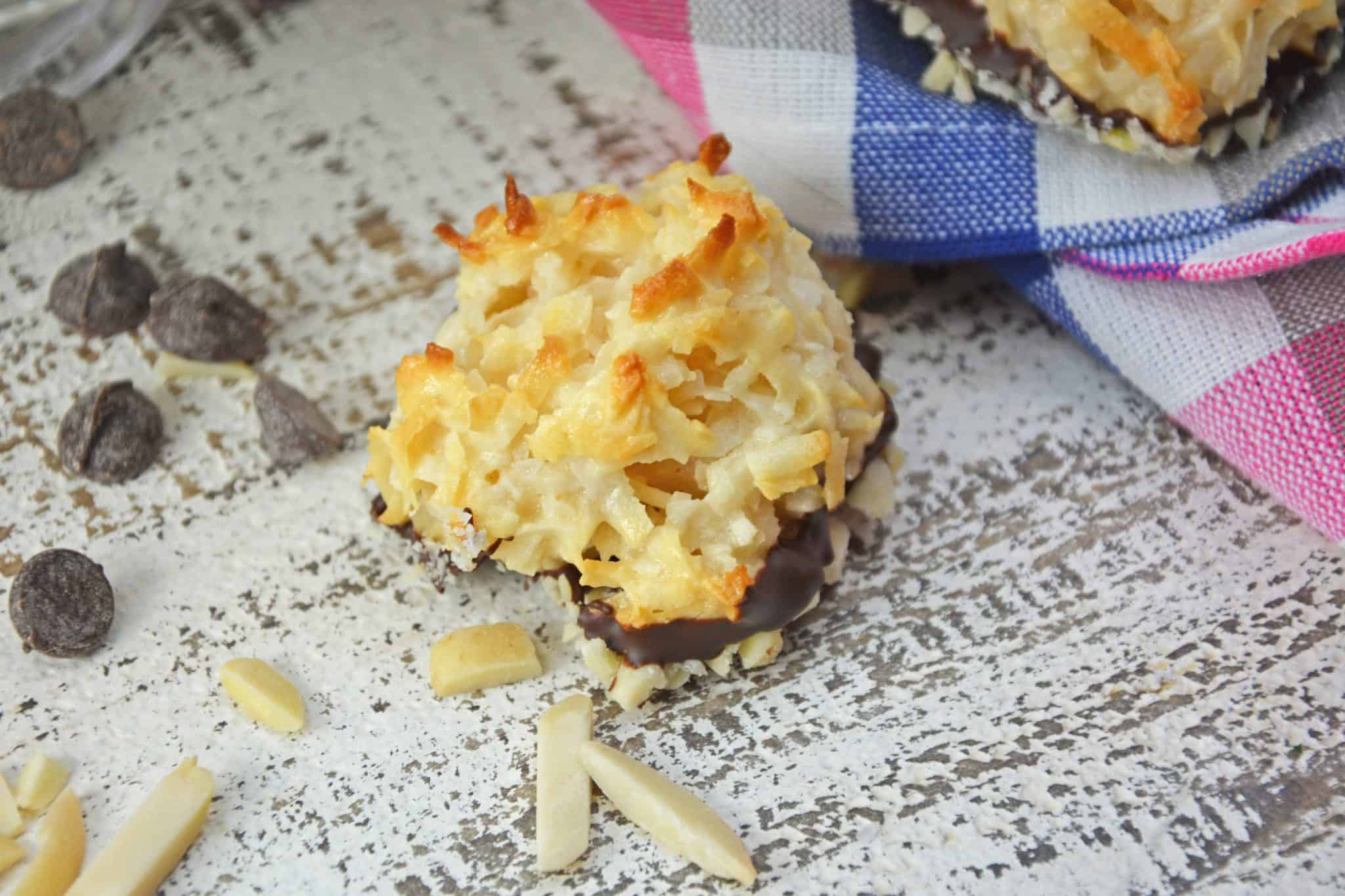 Almond Coconut Macaroons are light, fluffy coconut biscuits dipped in chocolate and almonds. Perfect as a dessert, for tea for as a an afternoon snack. #coconutmacaroons #macaroonsrecipe www.savoryexperiments.com 