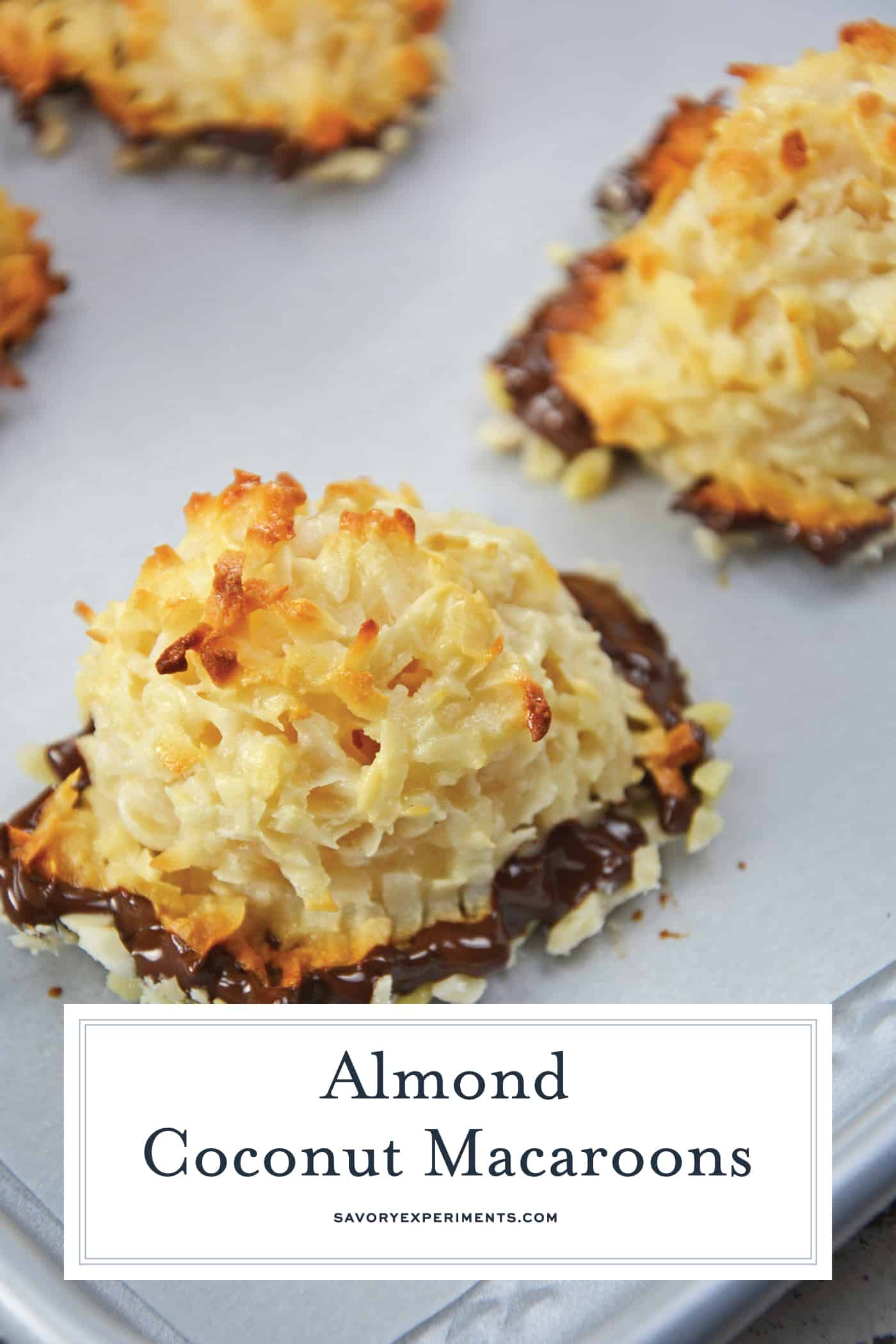 Almond Coconut Macaroons are light, fluffy coconut biscuits dipped in chocolate and almonds. Perfect as a dessert, for tea for as a an afternoon snack. #coconutmacaroons #macaroonsrecipe www.savoryexperiments.com