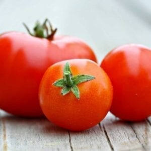 Learn how to peel a tomato in just a minute! Super easy without cooking the tomato. Perfect for sauces, salads and salsas! #howtopeelatomato #tomatoes www.savoryexperiments.com
