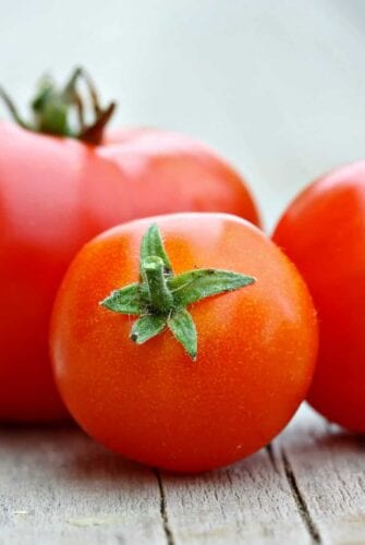 Learn how to peel a tomato in just a minute! Super easy without cooking the tomato. Perfect for sauces, salads and salsas! #howtopeelatomato #tomatoes www.savoryexperiments.com