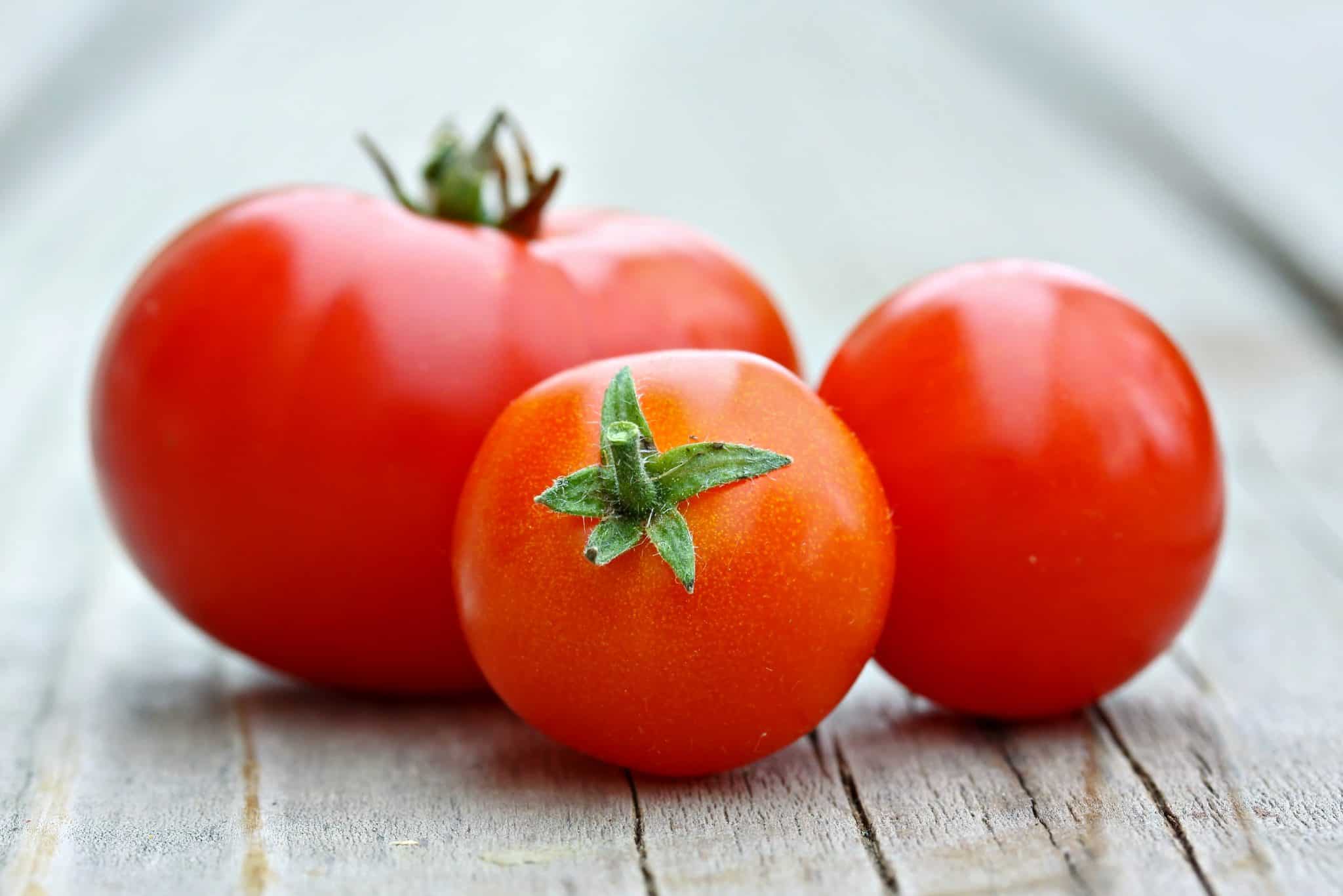 Learn how to peel a tomato in just a minute! Super easy without cooking the tomato. Perfect for sauces, salads and salsas! #howtopeelatomato #tomatoes www.savoryexperiments.com 