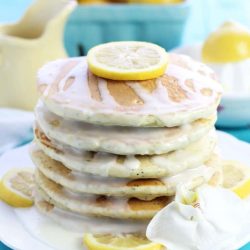 Stack of lemon poppyseed pancakes with white glaze and lemons