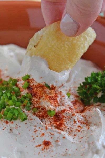 Chip being dipped into French Onion Dip