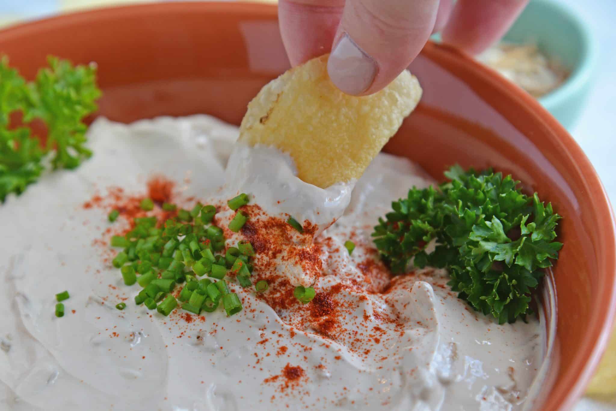 Chip being dipped into French Onion Dip