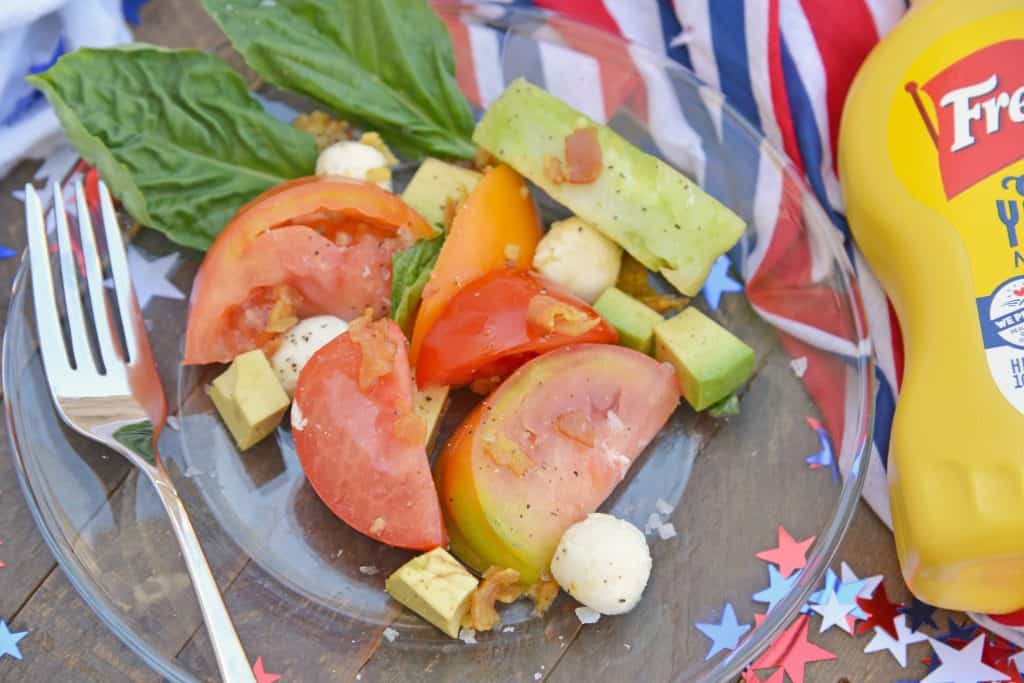 Tomato Salad with Mustard Bacon Dressing is the ultimate summer side dish using lush tomatoes, avocado mozzarella basil. Make it ahead for any party or BBQ. #tomatosalad #tomatorecipes www.savoryexperiments.com 