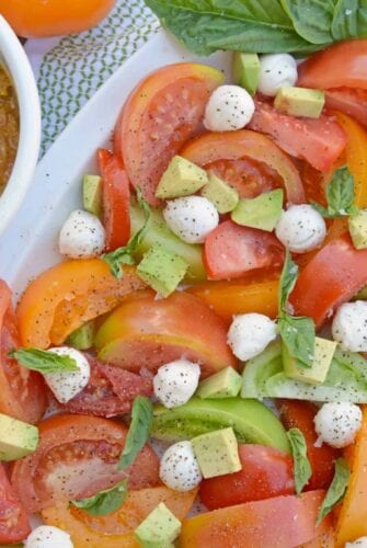 Tomato Salad with Mustard Bacon Dressing is the ultimate summer side dish using lush tomatoes, avocado mozzarella basil. Make it ahead for any party or BBQ. #tomatosalad #tomatorecipes www.savoryexperiments.com