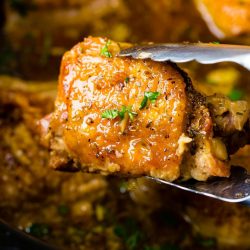 tongs holding garlic brown sugar chicken