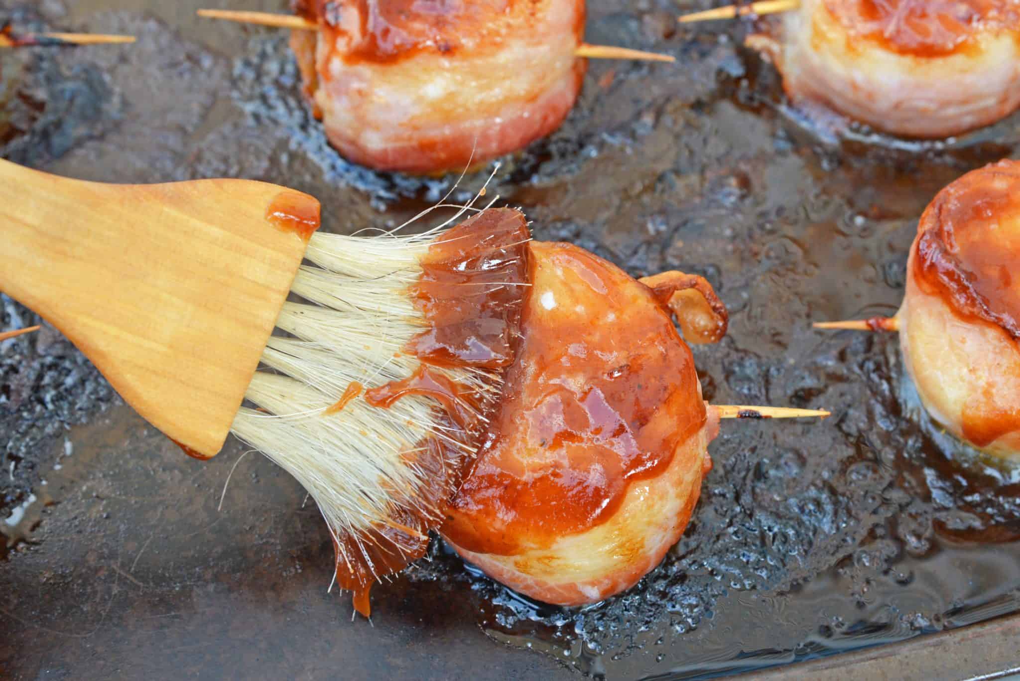 basting bacon wrapped scallops with BBQ sauce 
