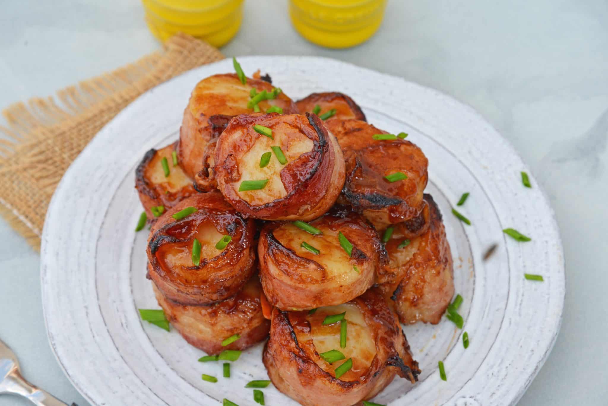 platter of bacon wrapped scallops with chives 