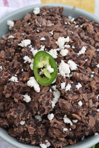 These homemade refried black beans are simple and easy to make and so versatile! Serve as a dip, on tacos, burritos or nachos or as a side to any dish! #homemaderefriedbeans #howtomakerefriedbeans #refriedblackbeans www.savoryexperiments.com