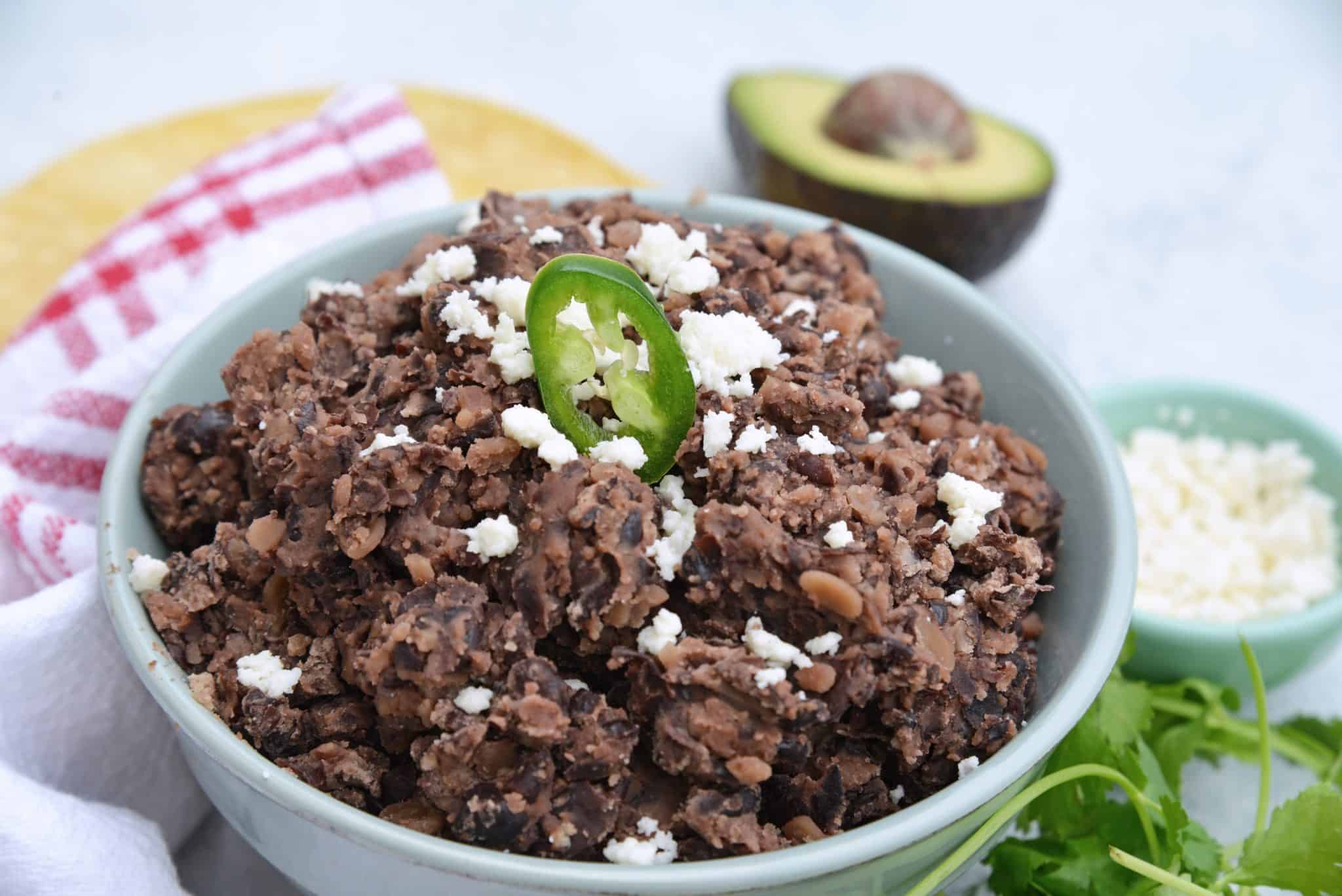 These homemade refried black beans are simple and easy to make and so versatile! Serve as a dip, on tacos, burritos or nachos or as a side to any dish! #homemaderefriedbeans #howtomakerefriedbeans #refriedblackbeans www.savoryexperiments.com