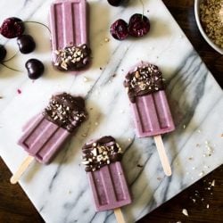 Four cherry popsicles on a white plate