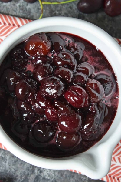 This Fresh Cherry Sauce is a yummy way to use fresh cherries. Spoon over ice cream, cake, waffles and more! #cherrysaucerecipe #freshcherryrecipes #desserttoppings www.savoryexperiments.com