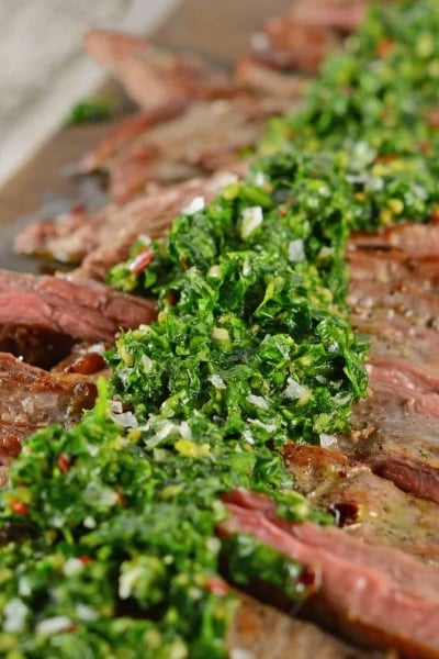 Skirt Steak Chimichurri is a grilled steak recipe that'll leave you drooling! Easy to make and topped with a delicious chimichurri sauce. #whatisskirtsteak #whatischimichurri #grilledsteakrecipe www.savoryexperiments.com