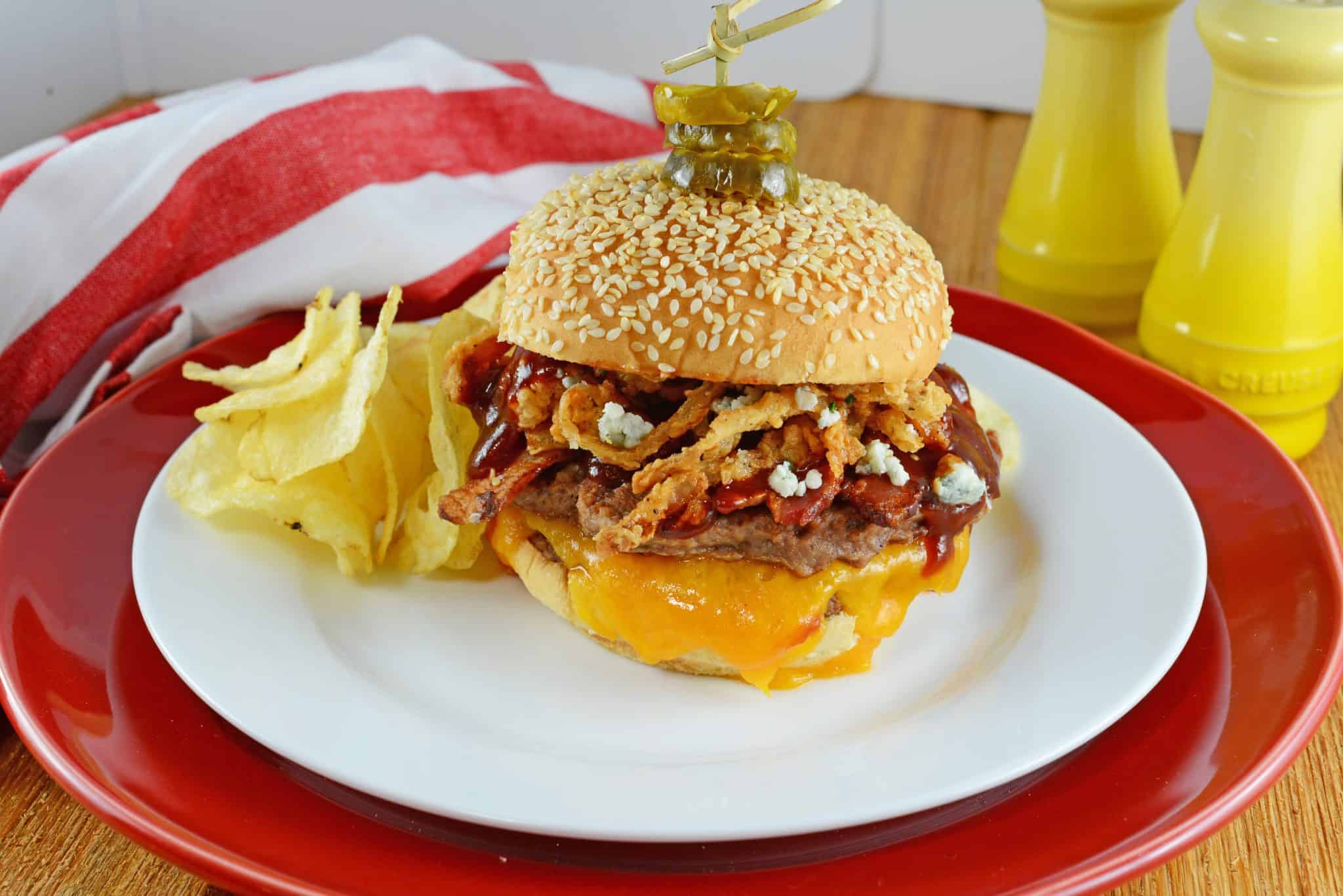 Cowboy burger with chips on a white plate