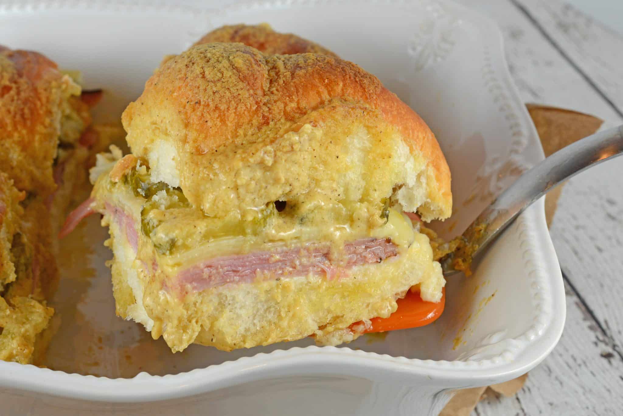 Cuban Sliders are made with layers of ham, pickles, and cheese between delicious sweet Hawaiian rolls. An easy and yummy appetizer! #cubansliders #minicubansandwiches www.savoryexperiments.com