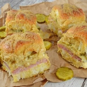 Cuban Sliders are made with layers of ham, pickles, and cheese between delicious sweet Hawaiian rolls. An easy and yummy appetizer! #cubansliders #minicubansandwiches www.savoryexperiments.com