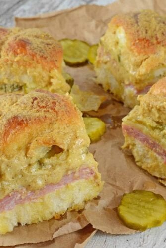 Cuban Sliders are made with layers of ham, pickles, and cheese between delicious sweet Hawaiian rolls. An easy and yummy appetizer! #cubansliders #minicubansandwiches www.savoryexperiments.com