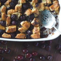 Dark chocolate cherry bread pudding in a white baking dish