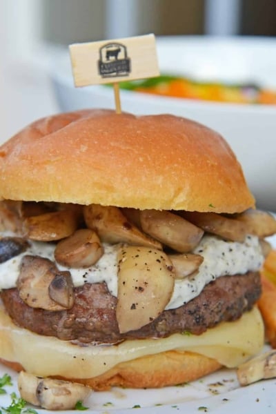 A Garlic Truffle Burger is the perfect way to make a gourmet burger at home. Truffle Aioli, sautéed mushrooms, Swiss cheese and a juicy burger patty on a buttery brioche roll. #gourmetburgers #truffleburgers www.savoryexperiments.com