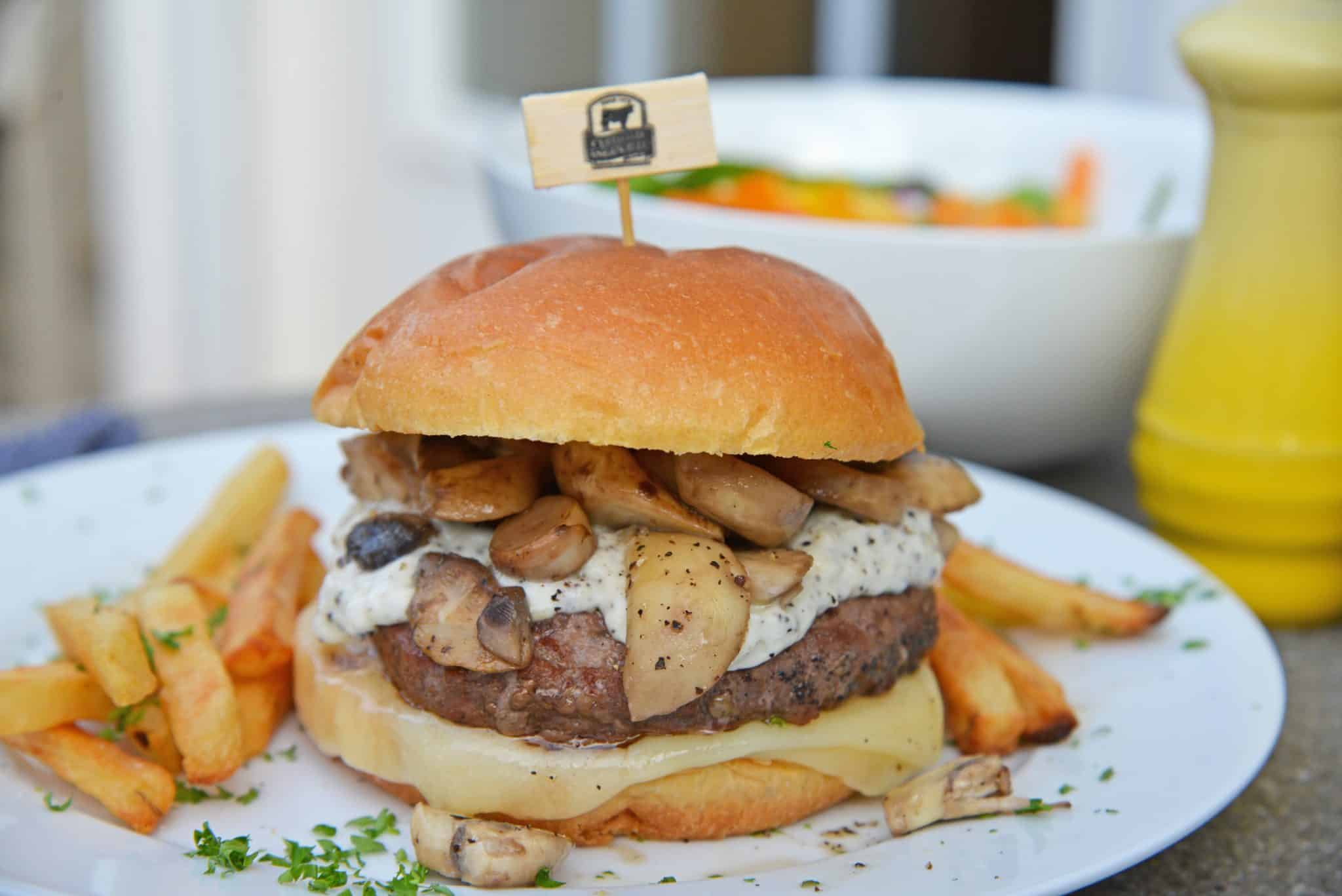 A Garlic Truffle Burger is the perfect way to make a gourmet burger at home. Truffle Aioli, sautéed mushrooms, Swiss cheese and a juicy burger patty on a buttery brioche roll. #gourmetburgers #truffleburgers www.savoryexperiments.com