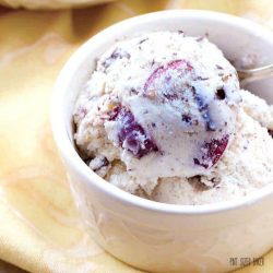 Two scoops of cherry garcia ice cream in a white bowl
