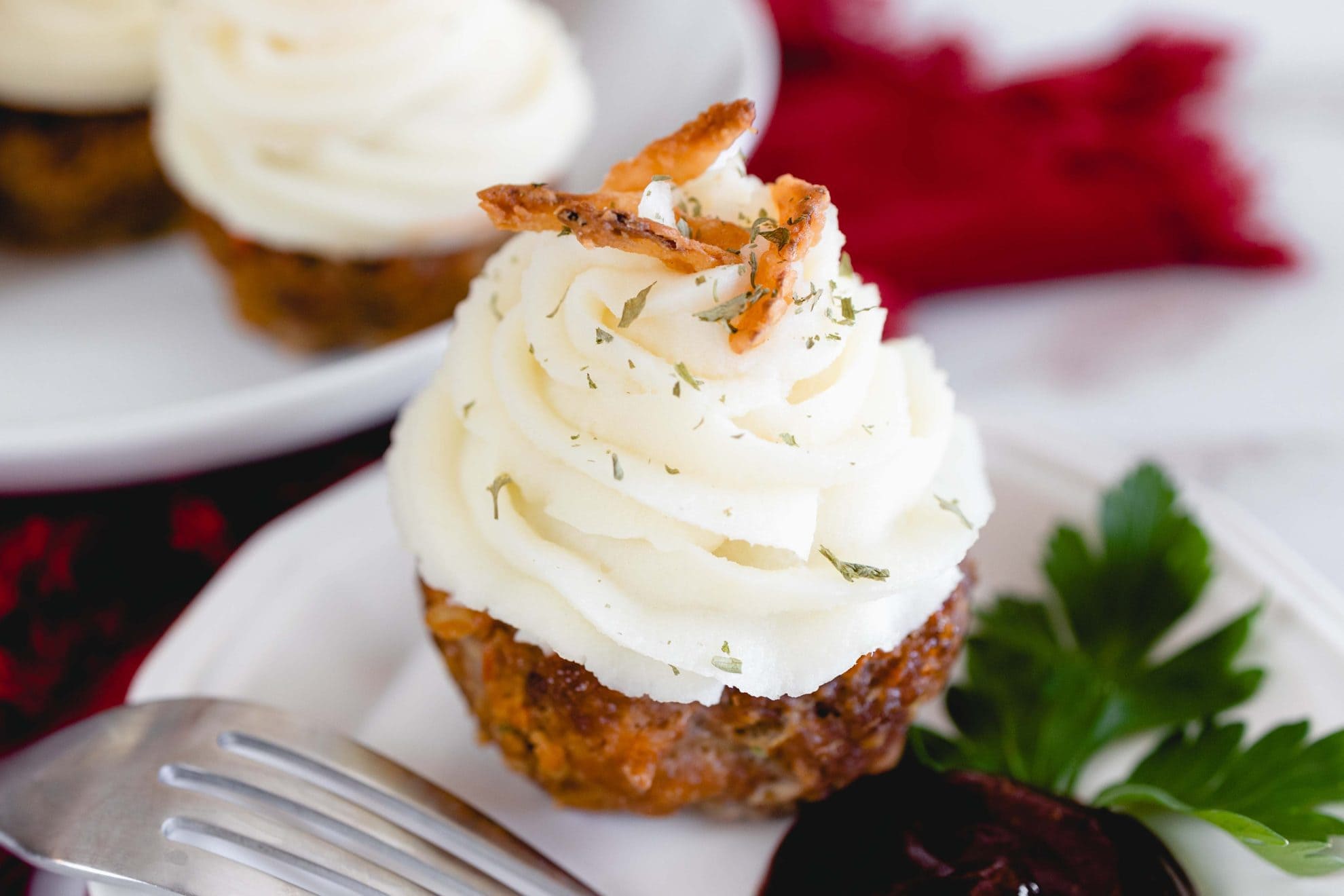 close up of a meatloaf muffin with mashed potatoes on top