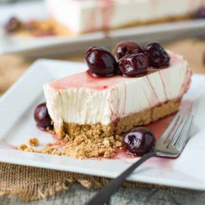 A slice of cherry lemon cheesecake on a white plate