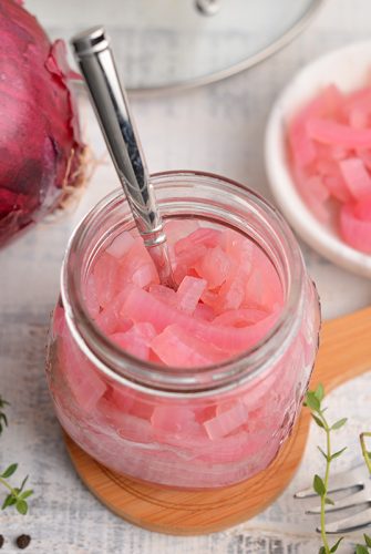 overview angle of pickled red onion in a small glass jar