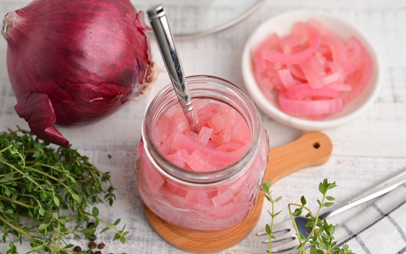 overview angle of pickled red onion in a small glass jar