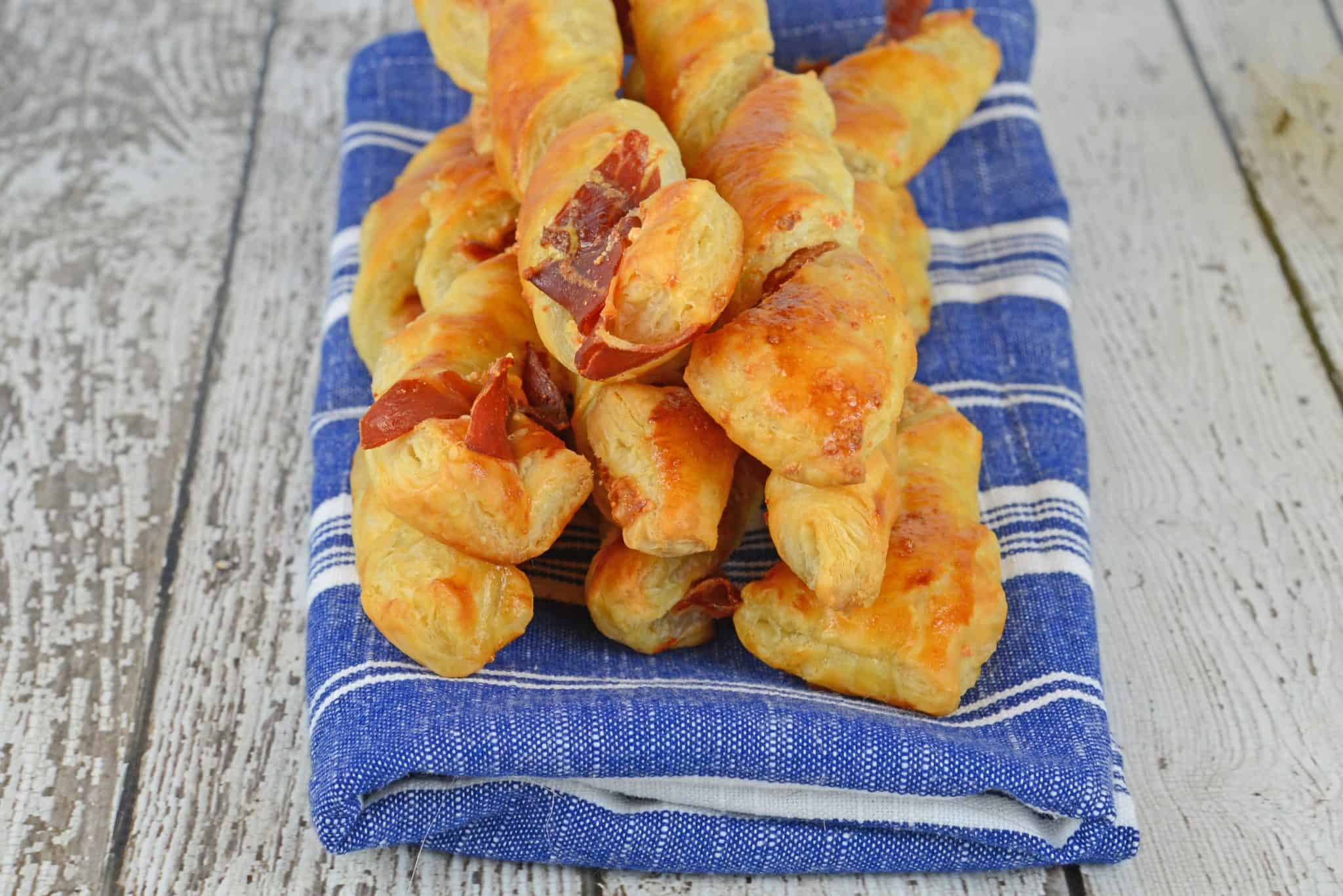 Prosciutto Parmesan Cheese Straws are made with just a few ingredients and 10 minutes in the oven! An easy appetizer for all occasions. #cheesestraws #puffpastrybreadsticks www.savoryexperiments.com