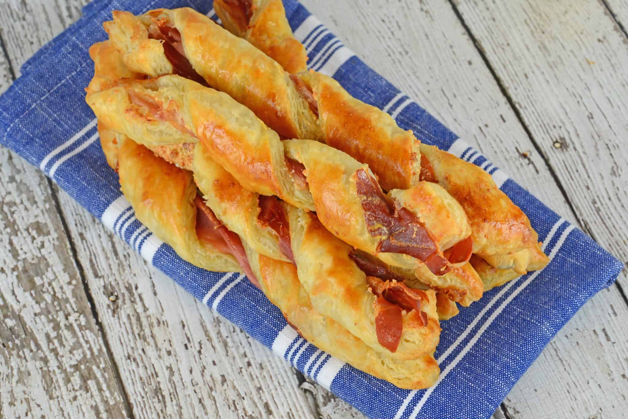 Prosciutto Parmesan Cheese Straws are made with just a few ingredients and 10 minutes in the oven! An easy appetizer for all occasions. #cheesestraws #puffpastrybreadsticks www.savoryexperiments.com