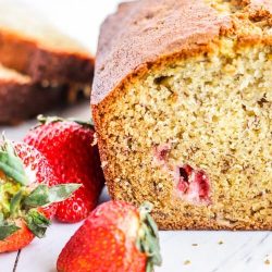 A loaf of strawberry banana bread with strawberries