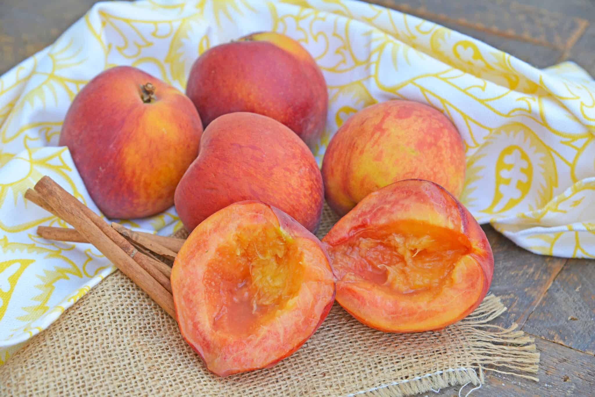 Grilled Peaches basted with cinnamon brown sugar and butter are the ultimate summer dessert idea. Add vanilla ice cream and fresh raspberries for dessert perfection! #grilledpeaches www.savoryexperiments.com