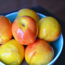 Blue bowl full of peaches