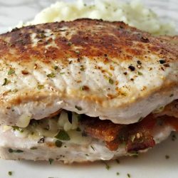 Gouda and bacon pork chops on a white plate