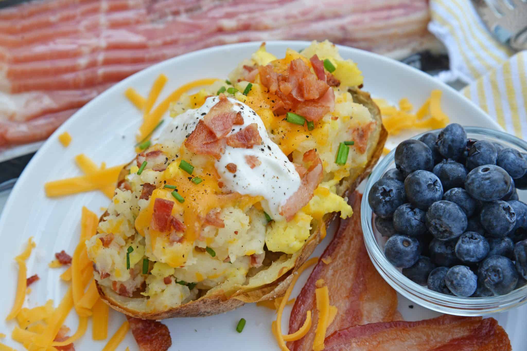 Twice Baked Breakfast Potatoes use leftover potatoes with scrambled eggs, cheddar cheese, chives, sour cream and BACON for the perfect easy breakfast recipe. #breakfastpotatoes www.savoryexperiments.com