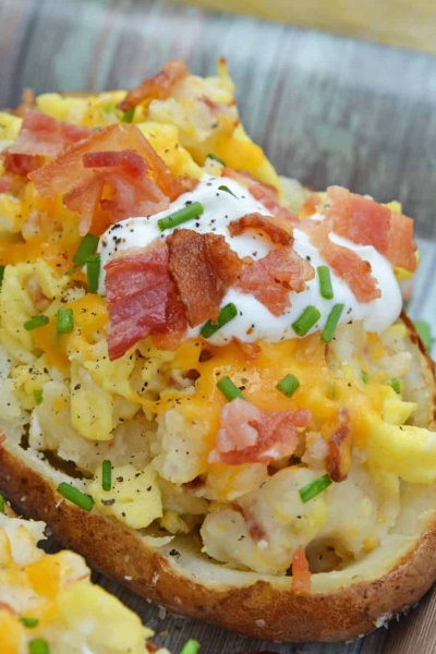 Twice Baked Breakfast Potatoes use leftover potatoes with scrambled eggs, cheddar cheese, chives, sour cream and BACON for the perfect easy breakfast recipe. #breakfastpotatoes www.savoryexperiments.com